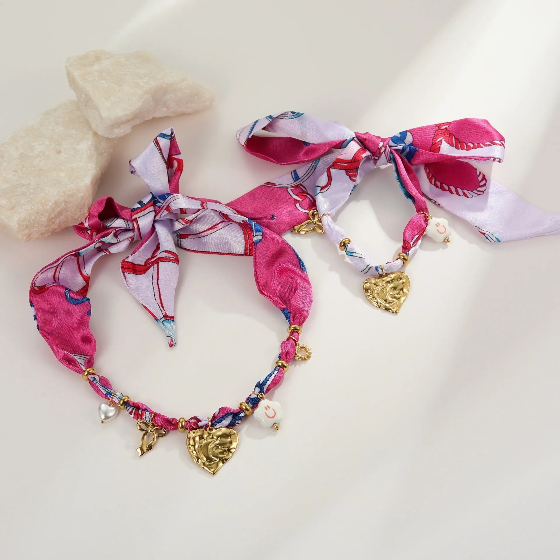 Stainless steel necklace and bracelet set with geometric pendant and gold electroplated finish.