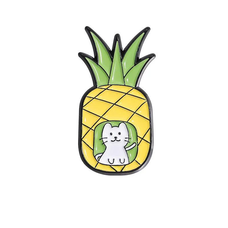 Colourful cartoon fruit design metal letter brooch on a fabric background.