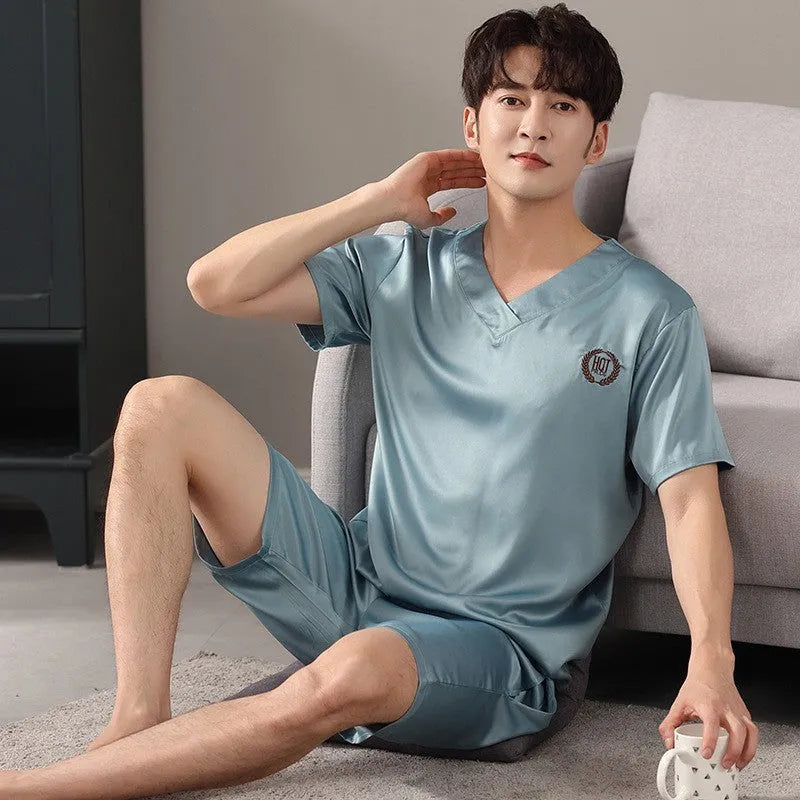 Man wearing a loose grey ice silk short-sleeve pyjama top and matching shorts.