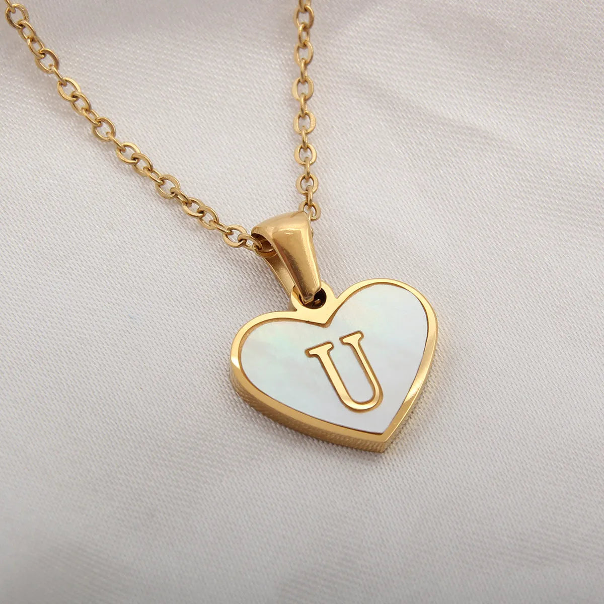Gold plated chain necklace with a white shell heart-shaped pendant personalised with a single letter initial.