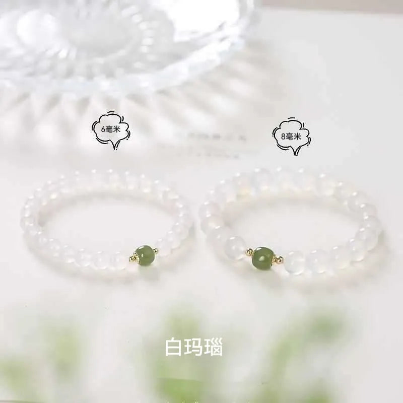 Handmade white agate and crystal bracelet with cinnabar inlay and text charm.
