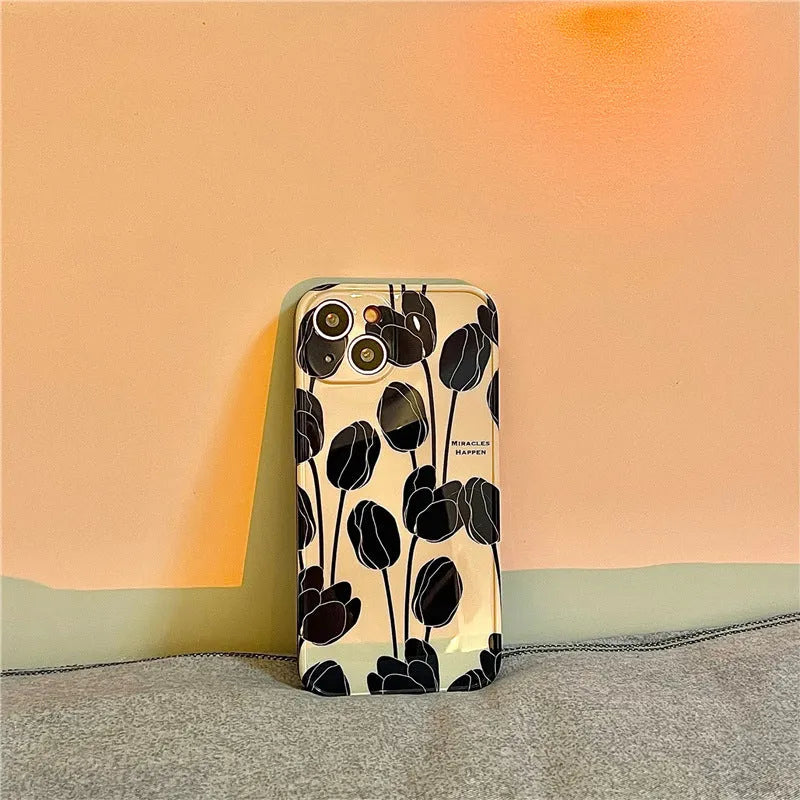 Black silicone iPhone case with a raised embossed tulip flower design on the back.
