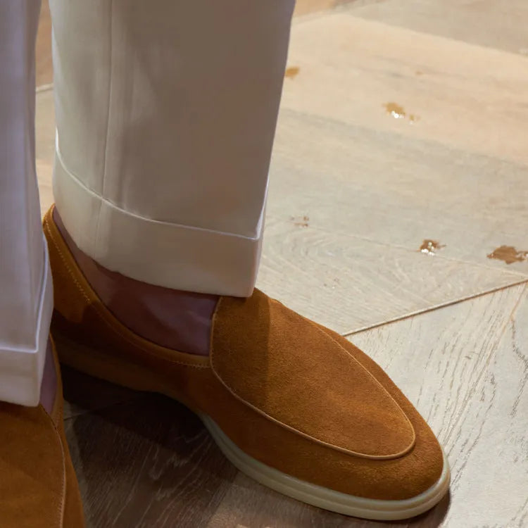 Men's brown genuine leather slip-on loafers on a white background.