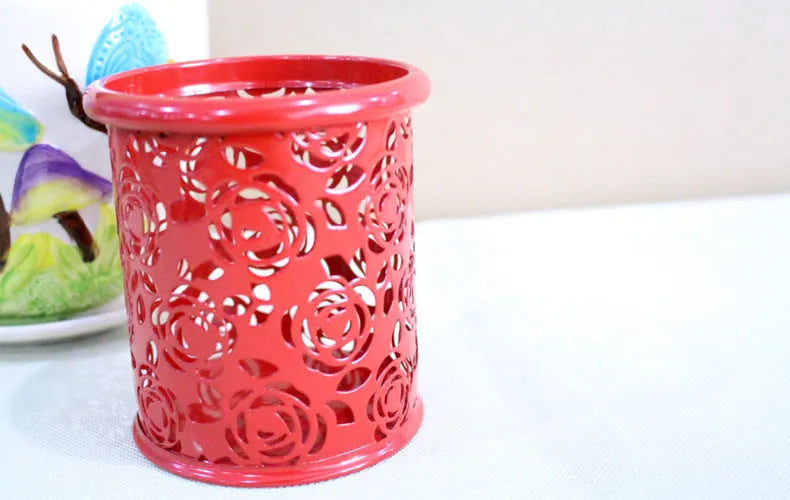 Metal round pen holder in Rose Red on a desk holding pens and pencils