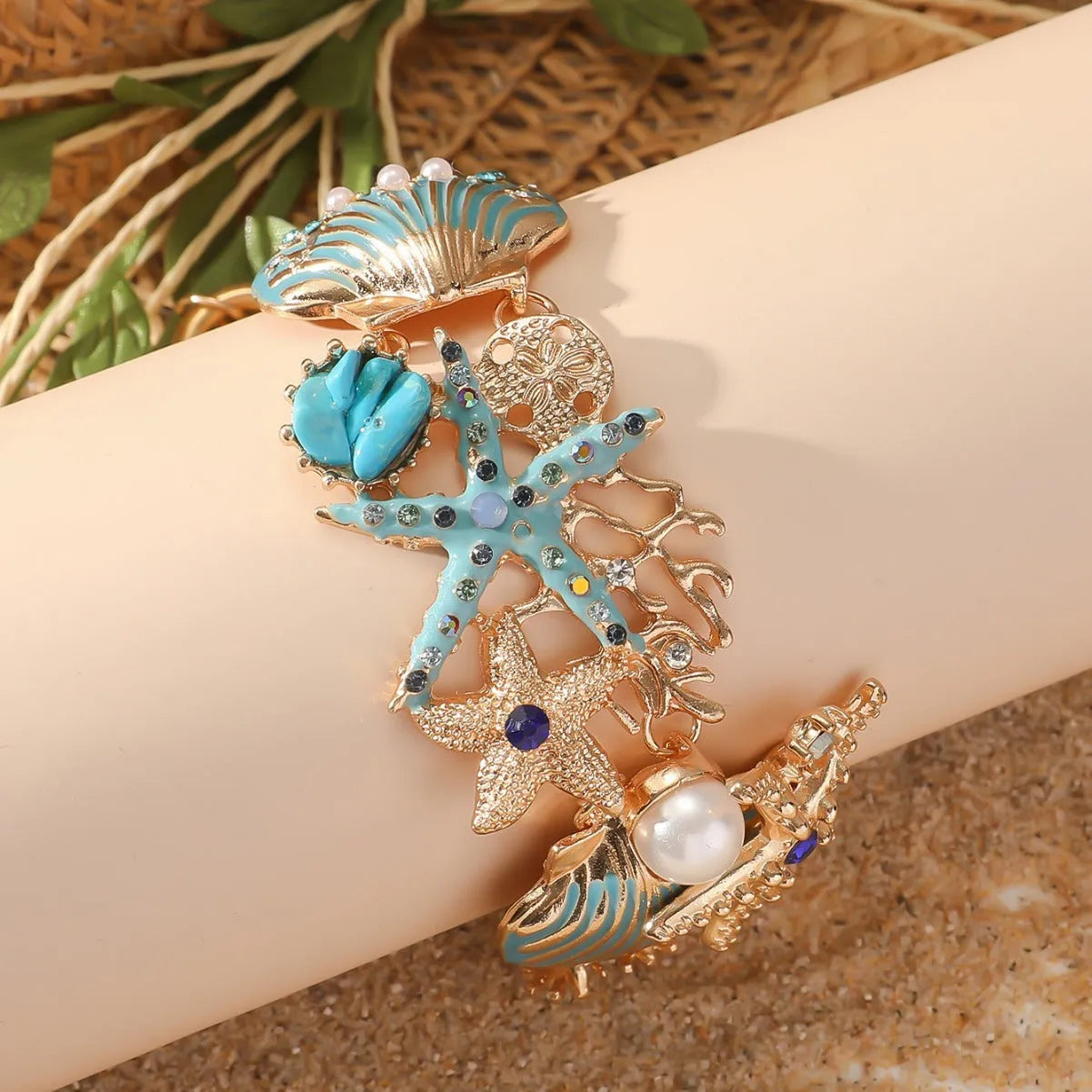 Alloy marine charm bracelet with shell, starfish, and anchor design in turquoise, red, or blue.