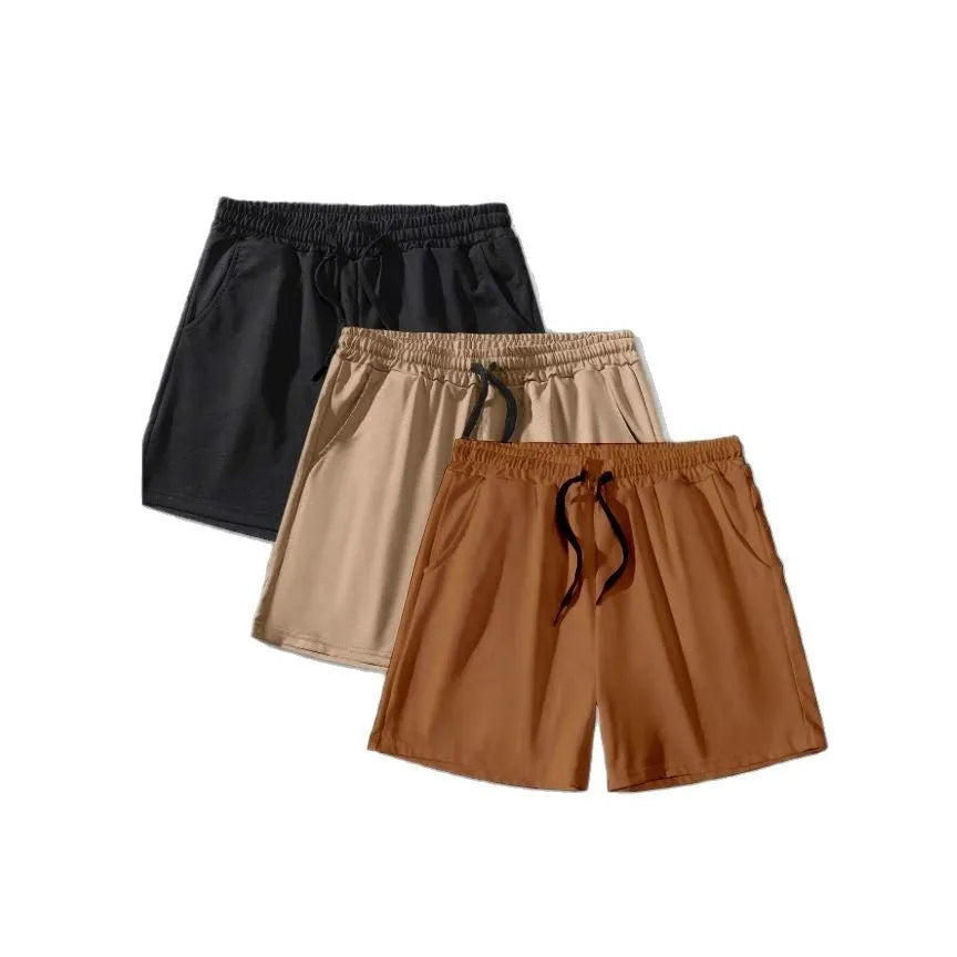 Pack of three men's solid colour drawstring shorts in loose fit on a plain background.