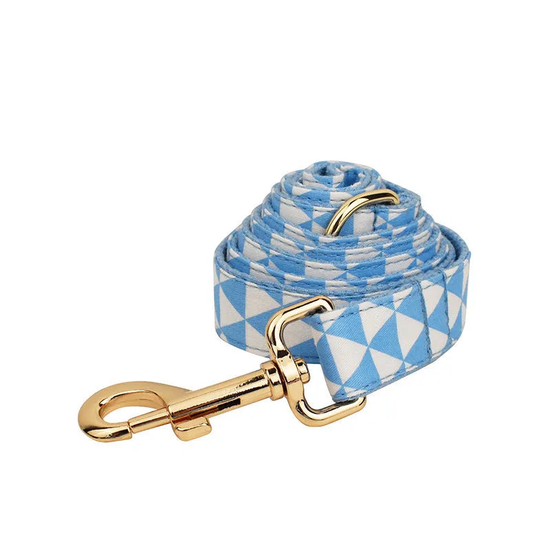 Blue triangular ring pattern dog accessory set with collar, leash, bow, and vest