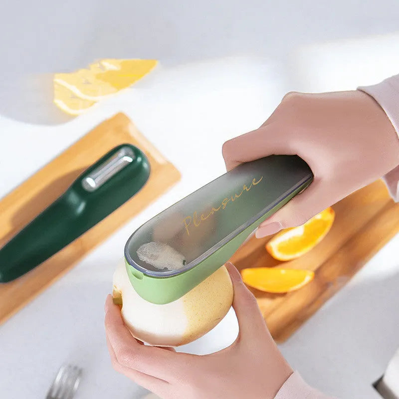 Dark green kitchen peeler with storage tube, showing stainless steel blade and non-slip handle.