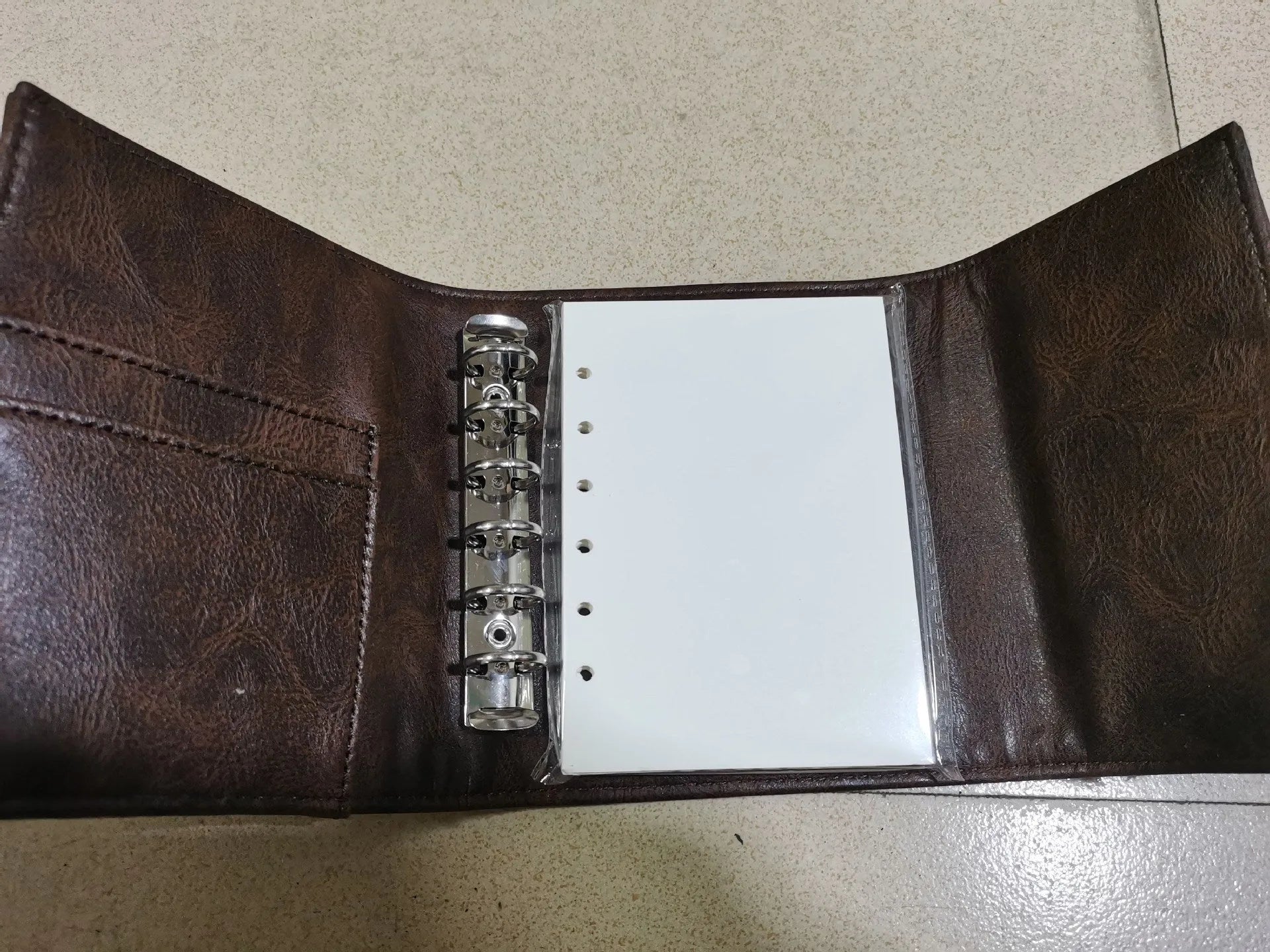 Brown retro-style A7 notebook with a leather buckle design and loose-leaf binding