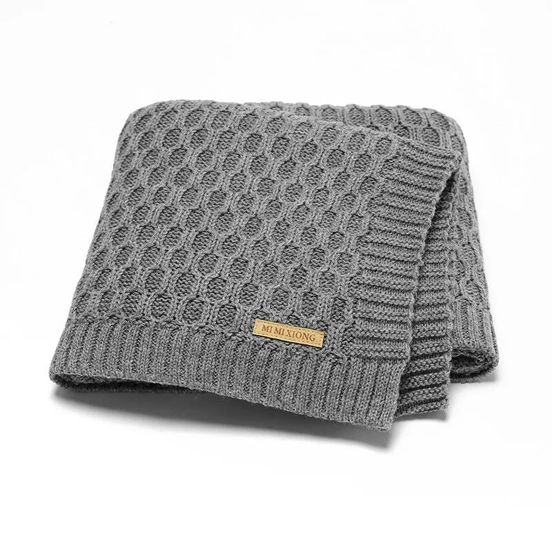 Solid colour infant hug blanket with three-dimensional lines, shown in one of five colour options.