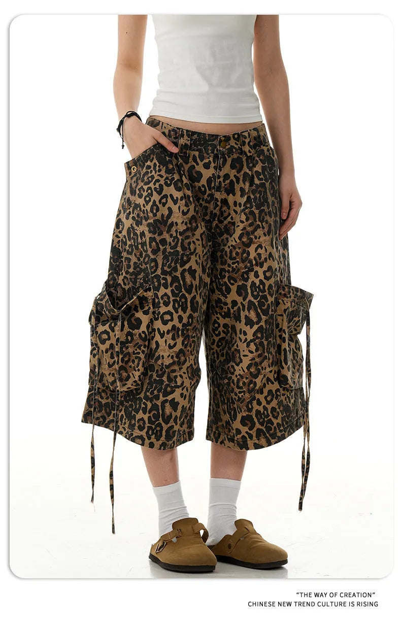 A pair of loose-fitting, high-waisted, straight-leg cropped pants in a leopard print pattern.