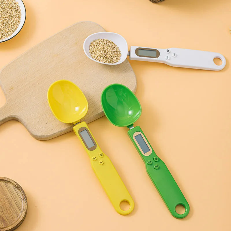 White digital spoon scale with LCD display measuring 500g capacity on a kitchen surface