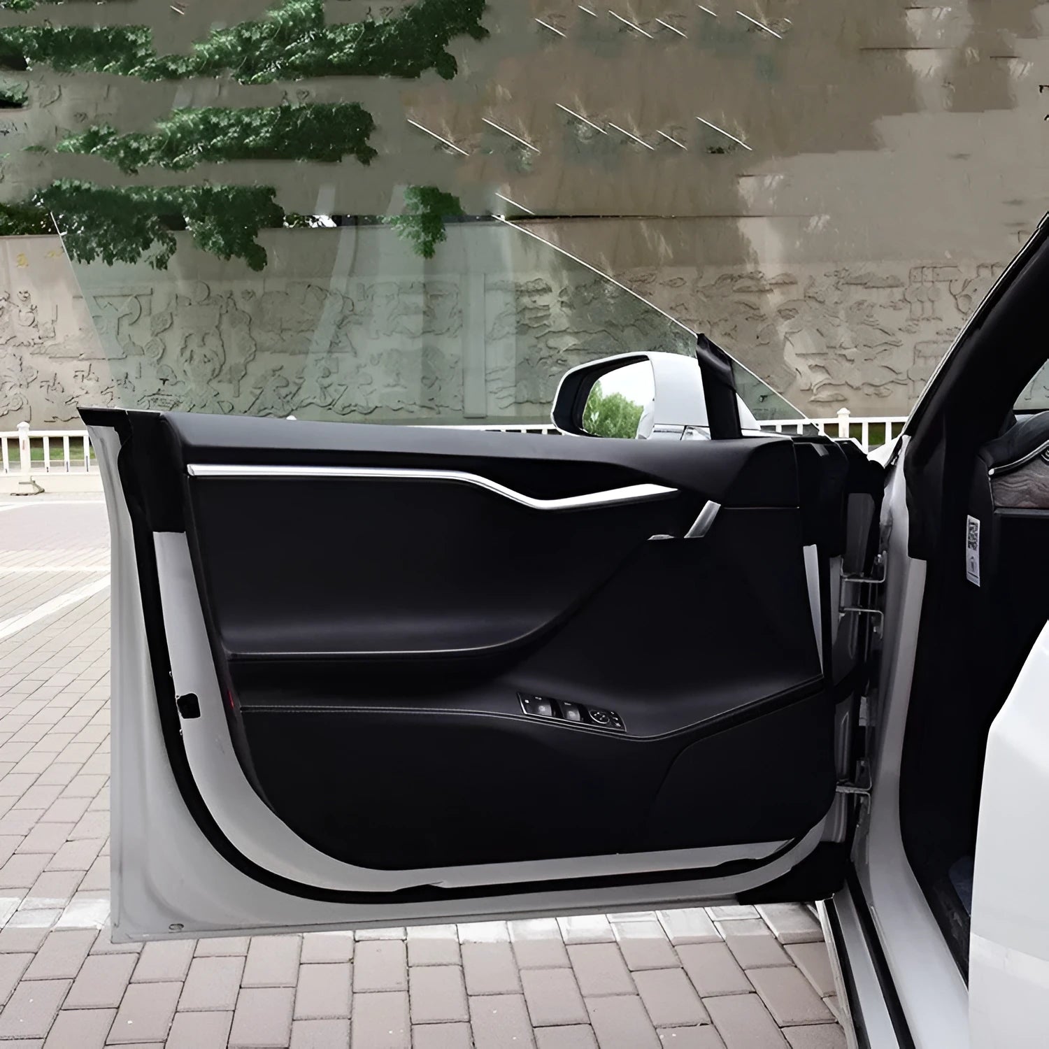 Four-piece clear protective film kit for Tesla Model S car door control panels.