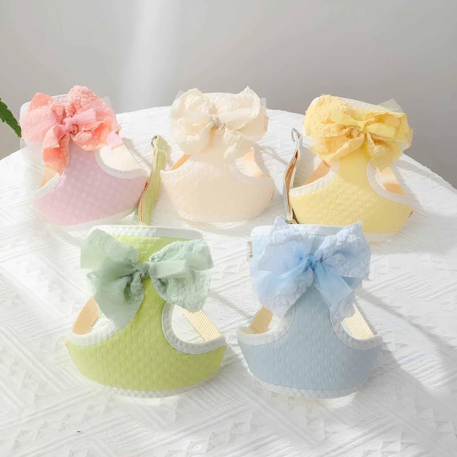 Small puppy hand-held rope chest strap in beige cloth on a wooden floor