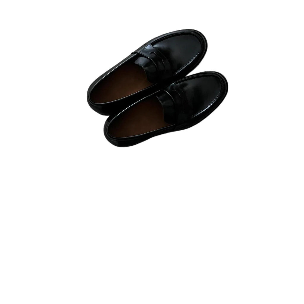 Men's black British-style slip-on leather loafers with stitched seams and vulcanised rubber sole on a plain background