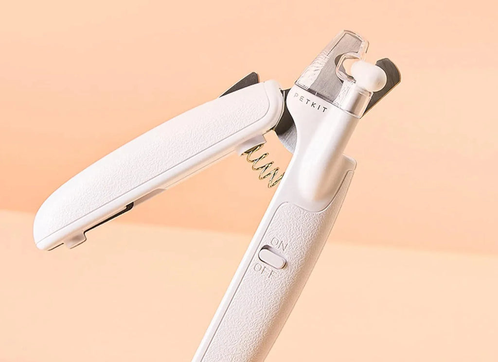 White pet nail clippers with LED light, transparent guard, triangular blades, and anti-slip handles for cat and dog grooming