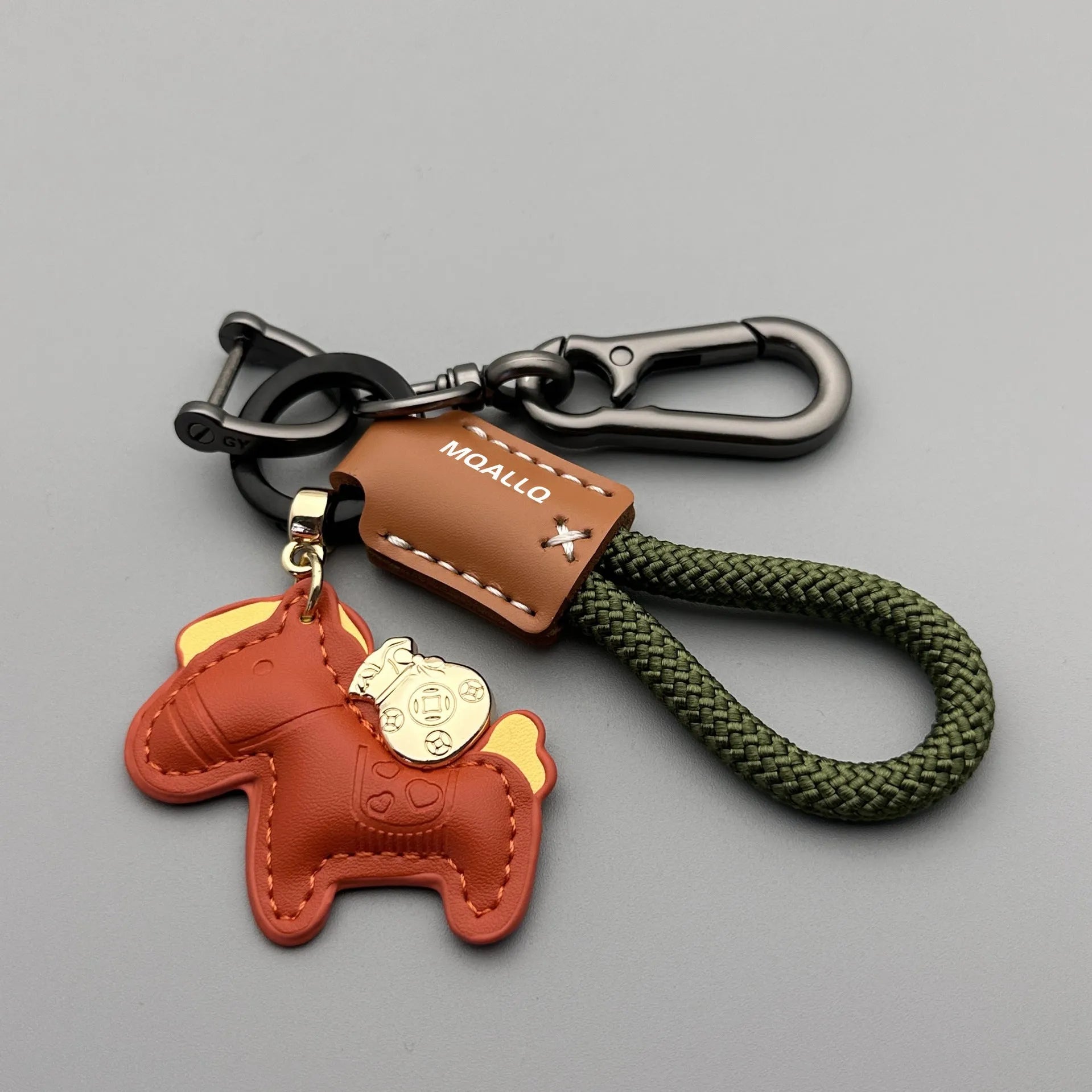 Handmade brown cowhide key ring pendant with a zinc alloy pony belt buckle and green flanelle rope.