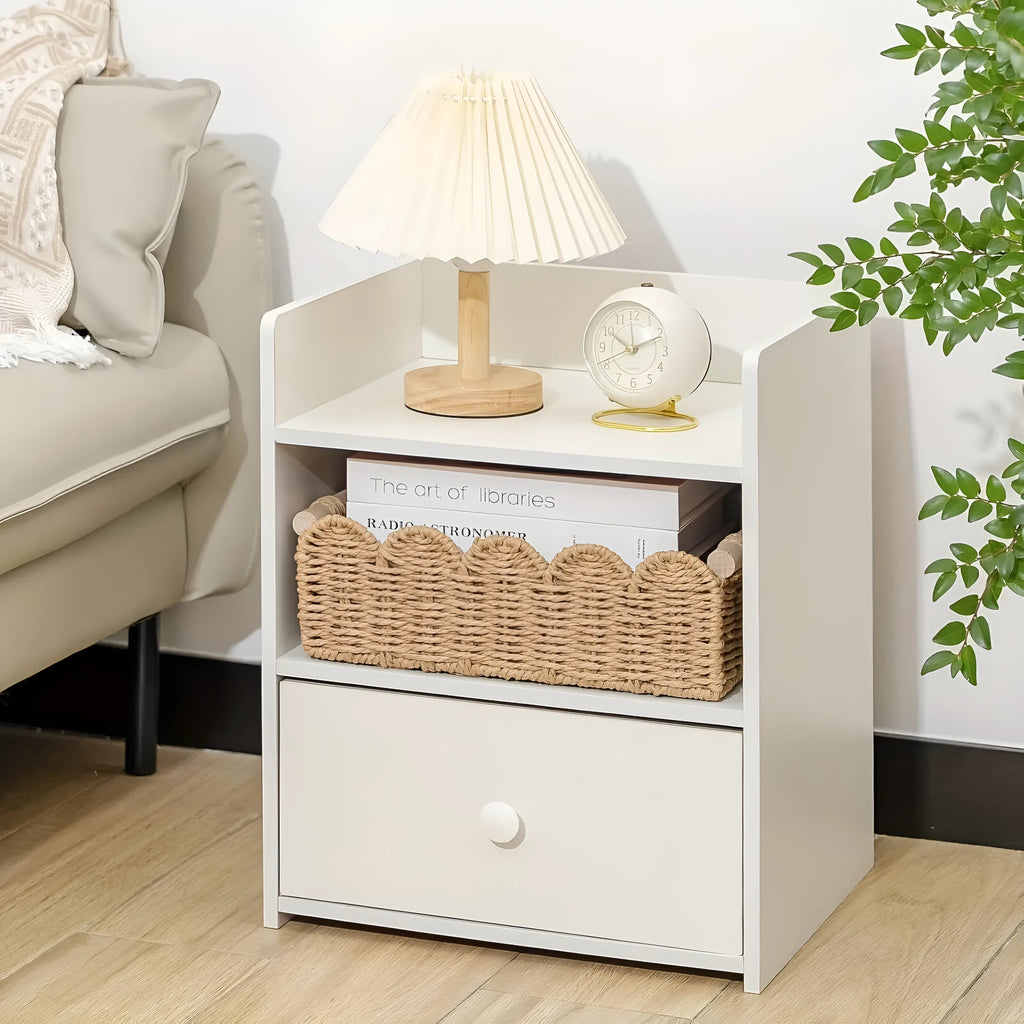 Woven paper storage basket in khaki colour on a desktop holding remote controls and pens.