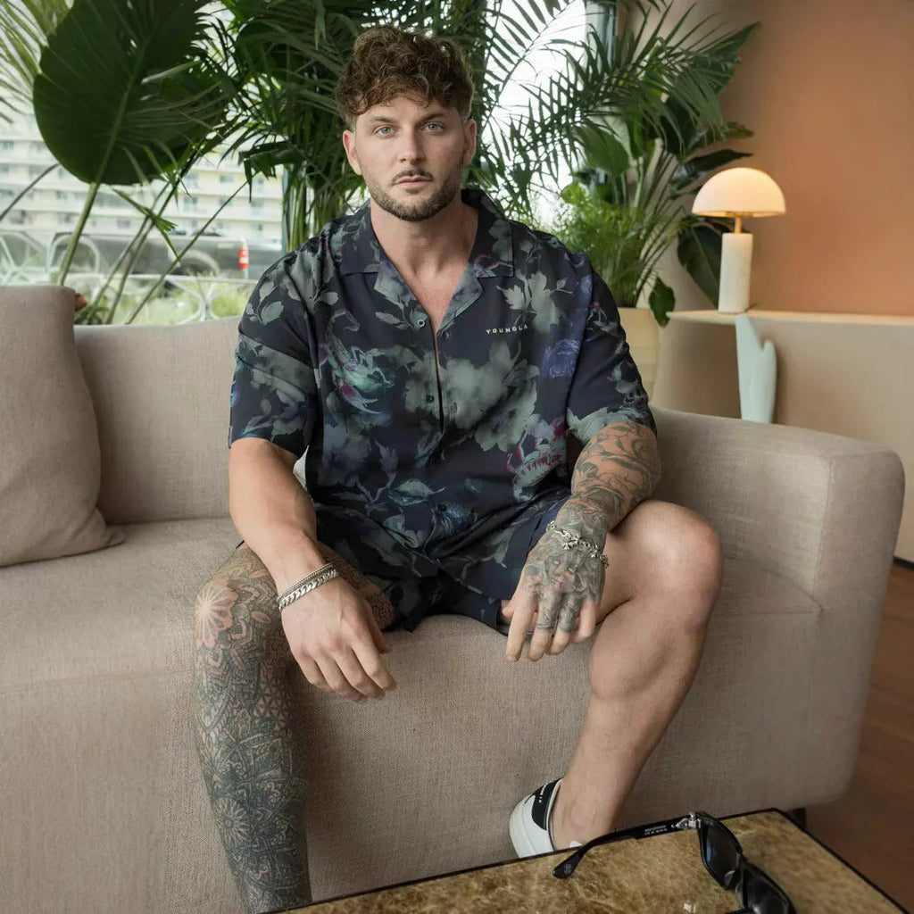 A man modelling a loose-fitting, short-sleeved beige cardigan with a printed floral pattern.