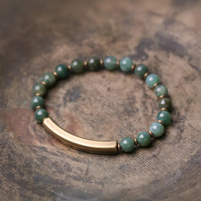 Layered ethnic bracelet with natural stones and brass components on a wrist