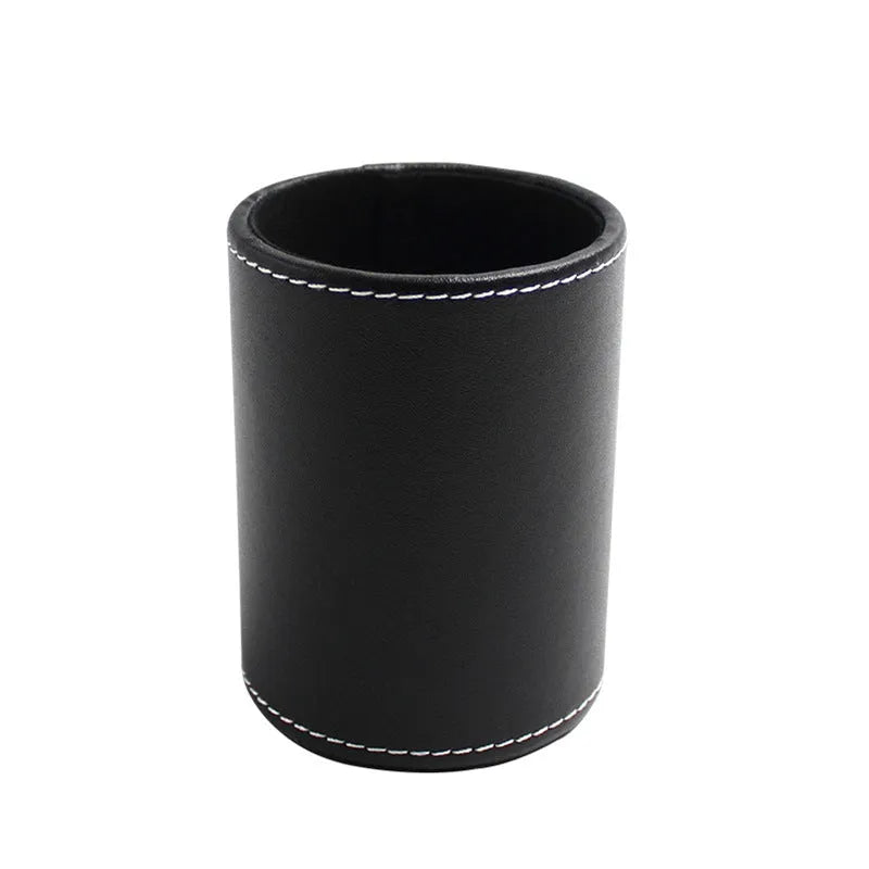 Small round black leather pen holder on a desk.