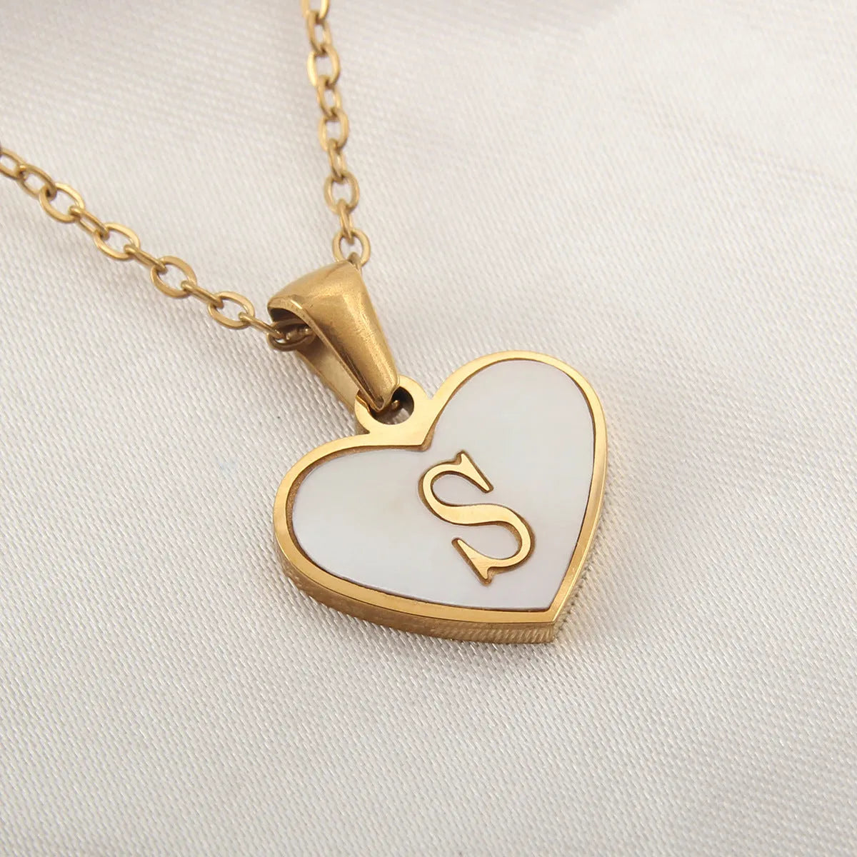 Gold plated chain necklace with a white shell heart-shaped pendant personalised with a single letter initial.