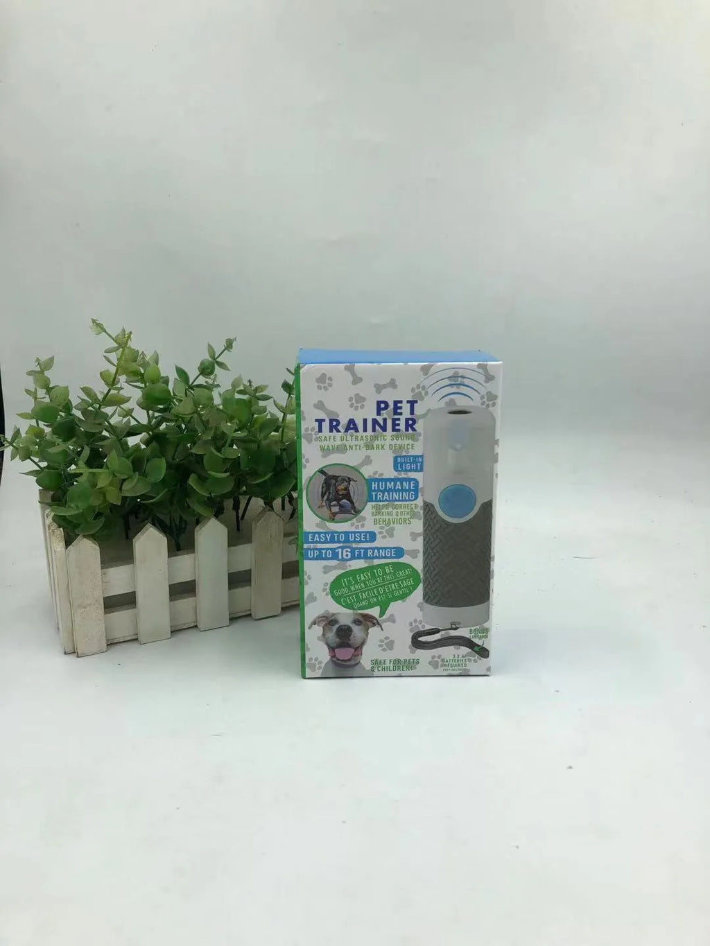 White handheld ultrasonic dog bark control trainer unit on a plain background.