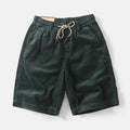 Man wearing khaki retro-style cargo shorts with straight leg and cargo pockets.