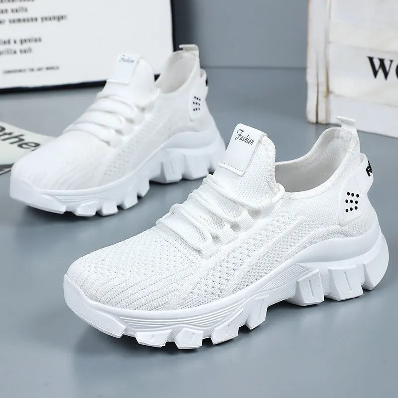 Women's white Flyknit running sneakers with thick PVC sole and lace-up front.