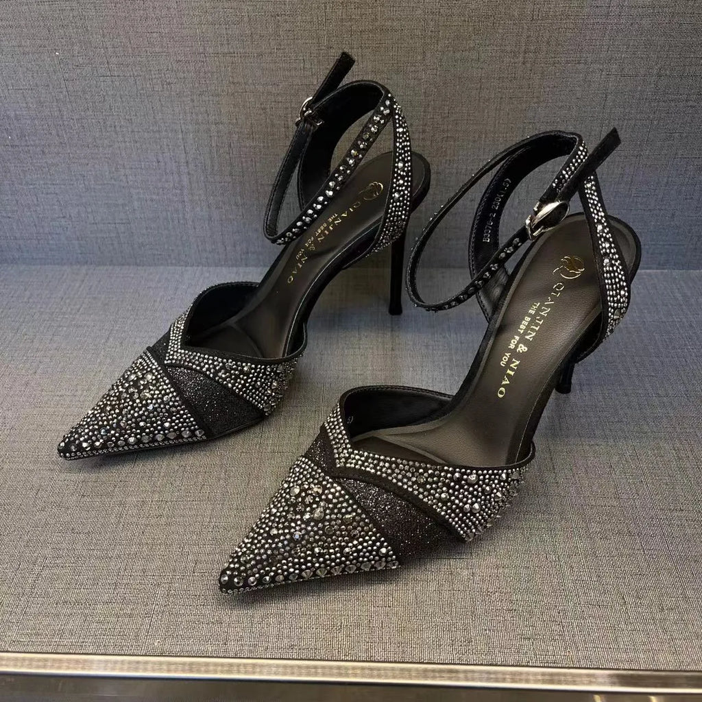 Women's black high heel shoe with a red sole, pointed toe, and a hollow stiletto heel on a plain background.