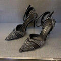 Women's black high heel shoe with a red sole, pointed toe, and a hollow stiletto heel on a plain background.