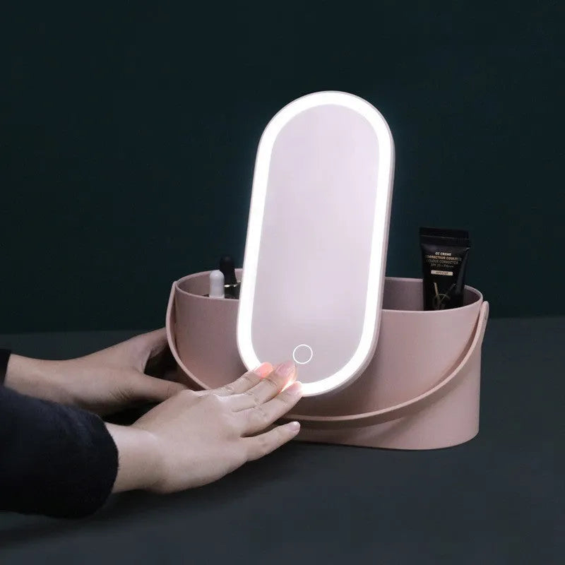Portable LED light storage box beauty and makeup mirror with aluminium mirror lens in pink colour on a bedroom surface.
