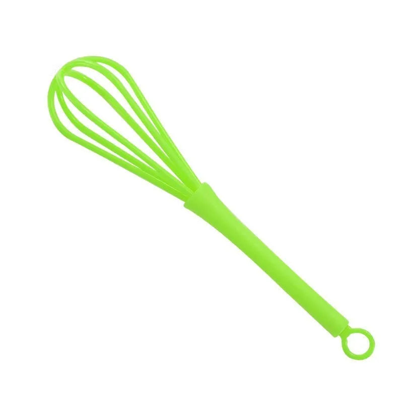 Plastic mini manual eggbeater in green for stirring batter in a kitchen
