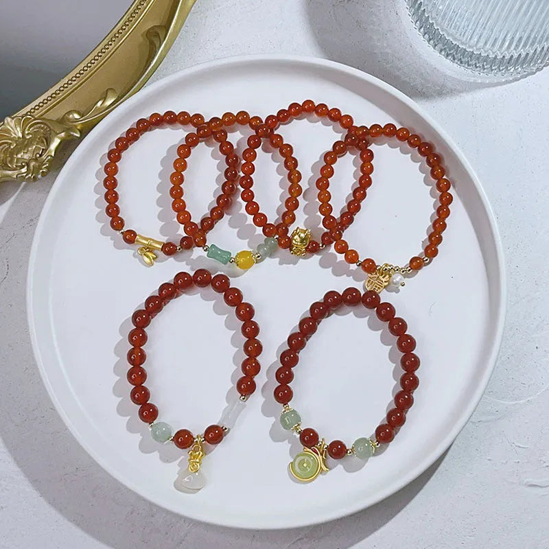 Close-up of a red agate bracelet with a Chinese dragon design on a woman's wrist.