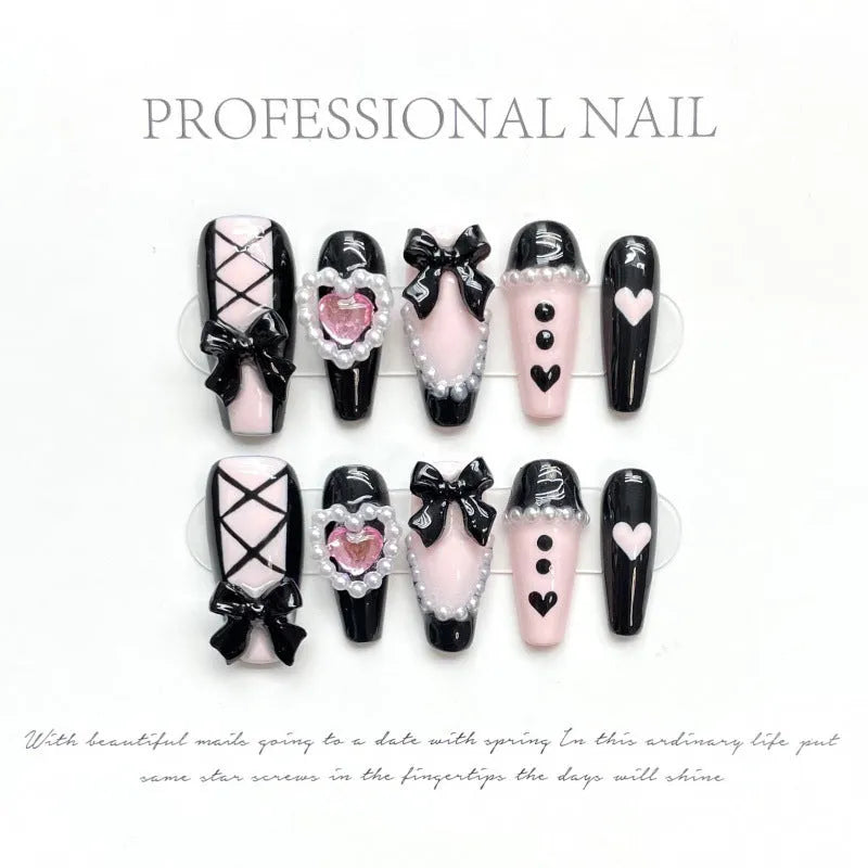 Handmade black and pink heart-shaped false nails with Cat's Eye, Bow, and XINGX hand-painted designs.