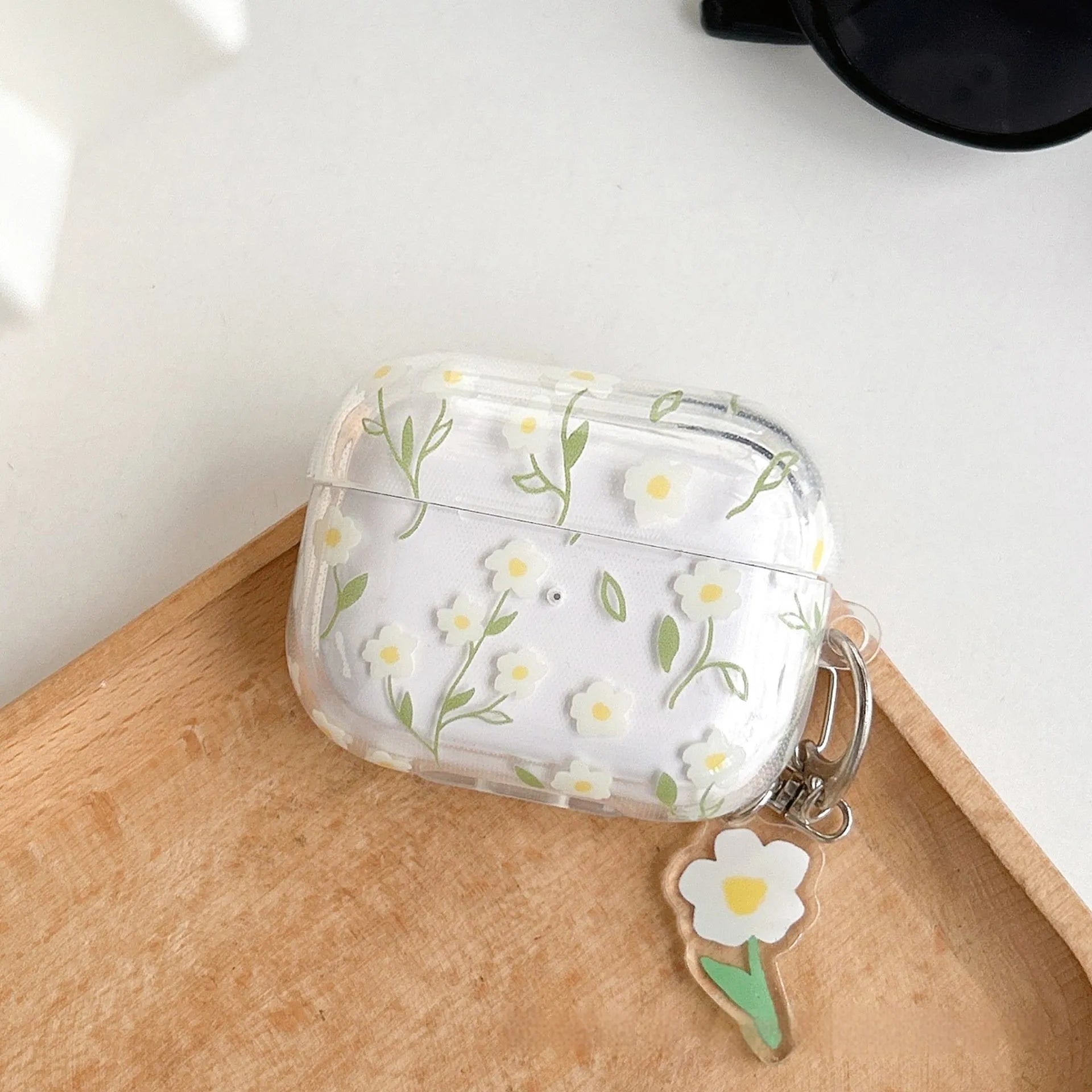 Transparent white floral TPU protective cover for Apple AirPods showing charging port access