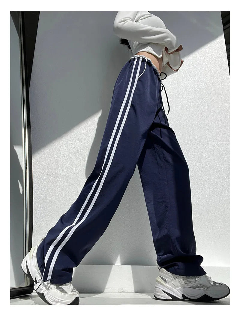 Women's loose straight-leg trousers with contrast ribbon detail in navy blue.