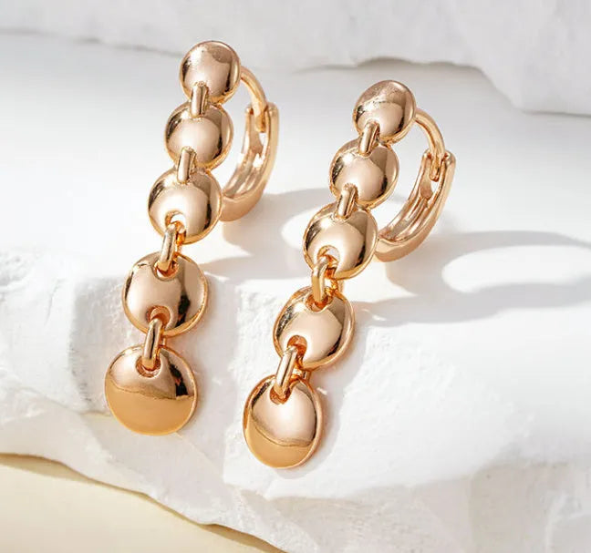 A pair of gold-coloured retro long round circle earrings with a woven copper texture.