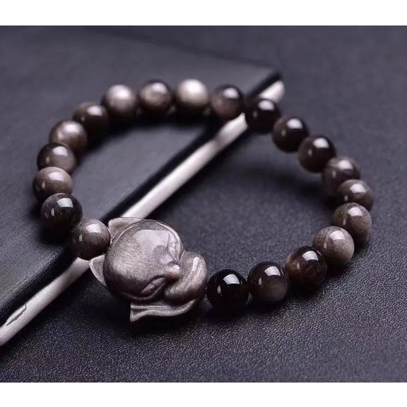 Women's obsidian bracelet with a single 8mm polished bead and a silver fox charm on an adjustable leather cord.