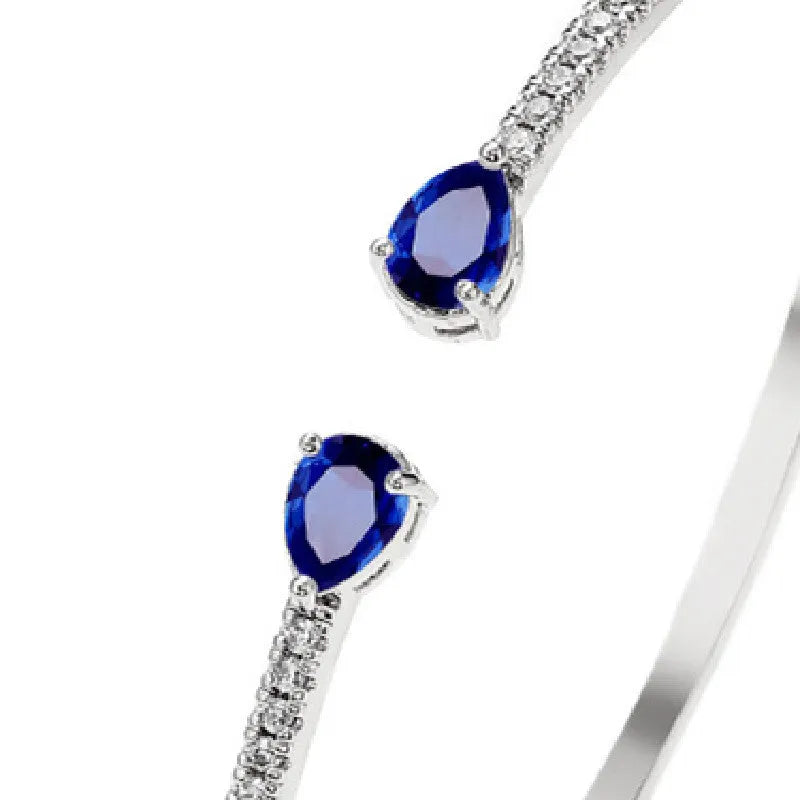 Adjustable copper bracelet with inlaid white zircon stones on a wrist.