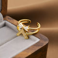 Gold geometric open-back adjustable fashion ring on a flat surface.