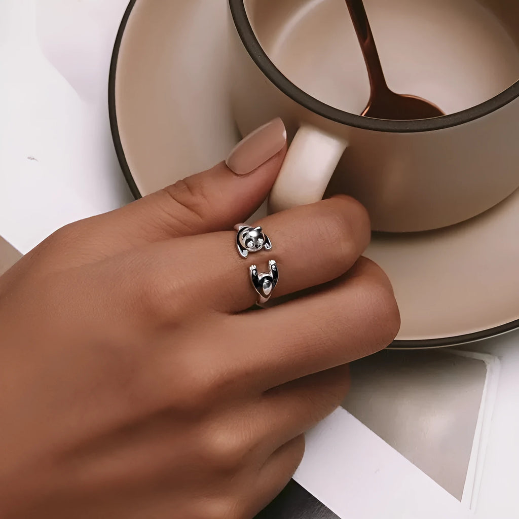 Adjustable sterling silver panda ring with white gold plating on a finger