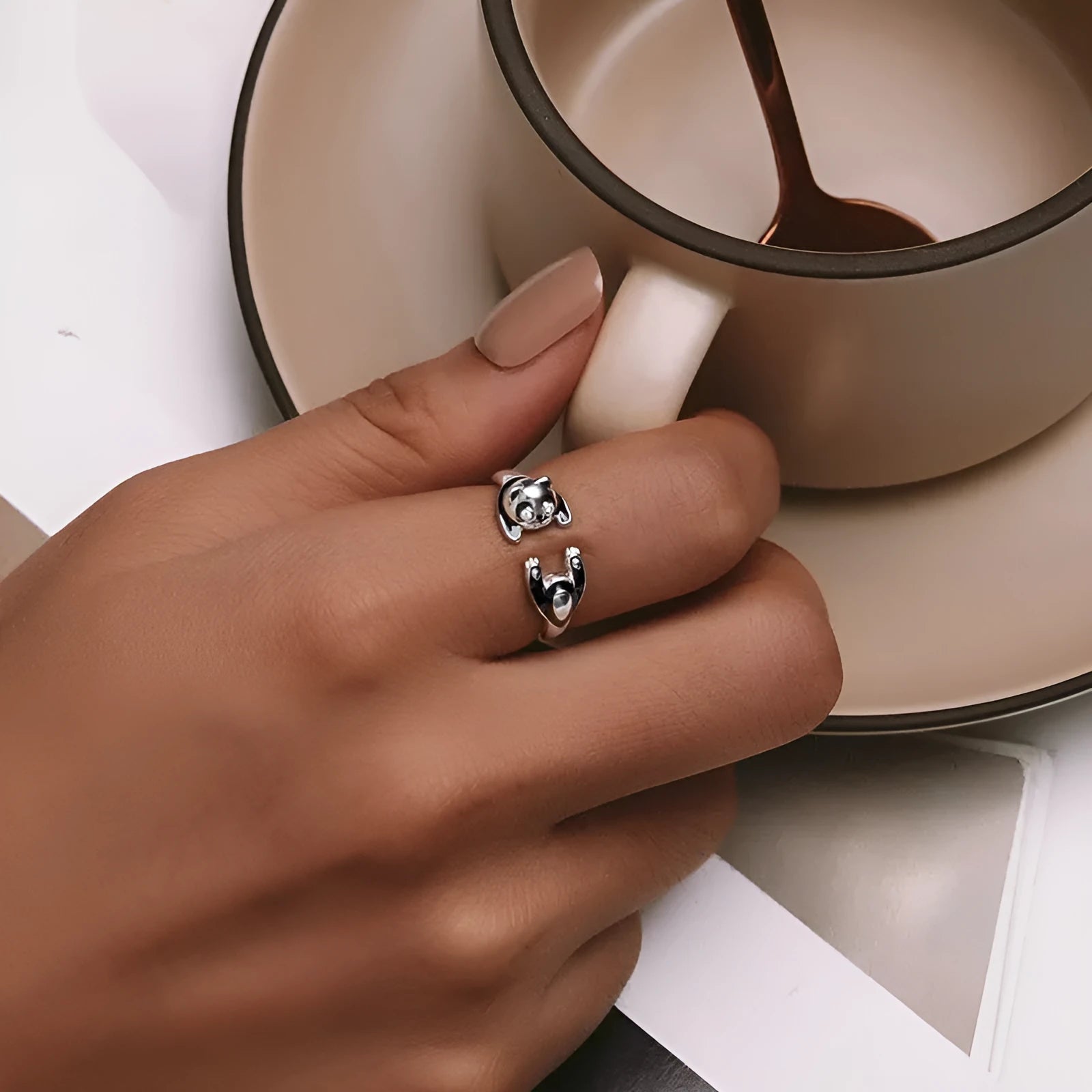 Adjustable sterling silver panda ring with white gold plating on a finger