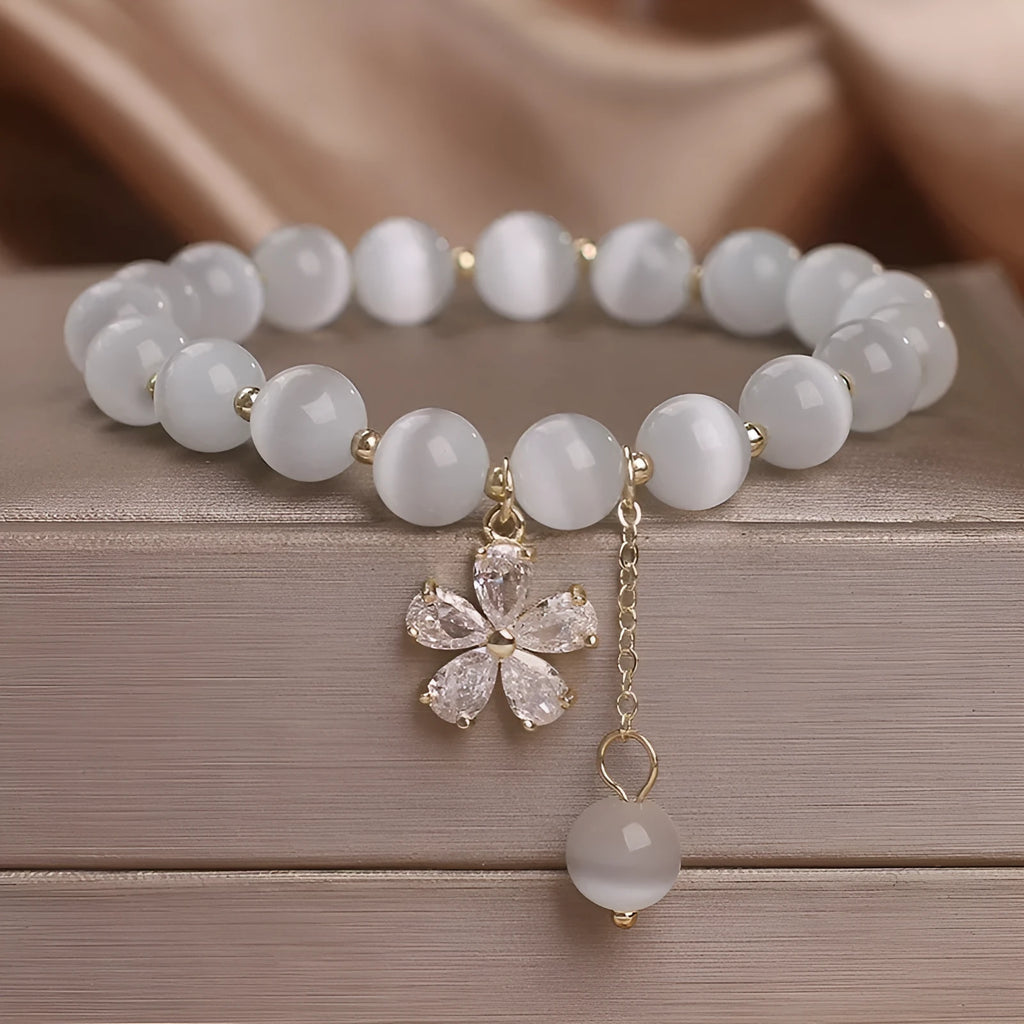 White Cat's Eye stone bracelet with a small flower tassel pendant and a safety buckle.