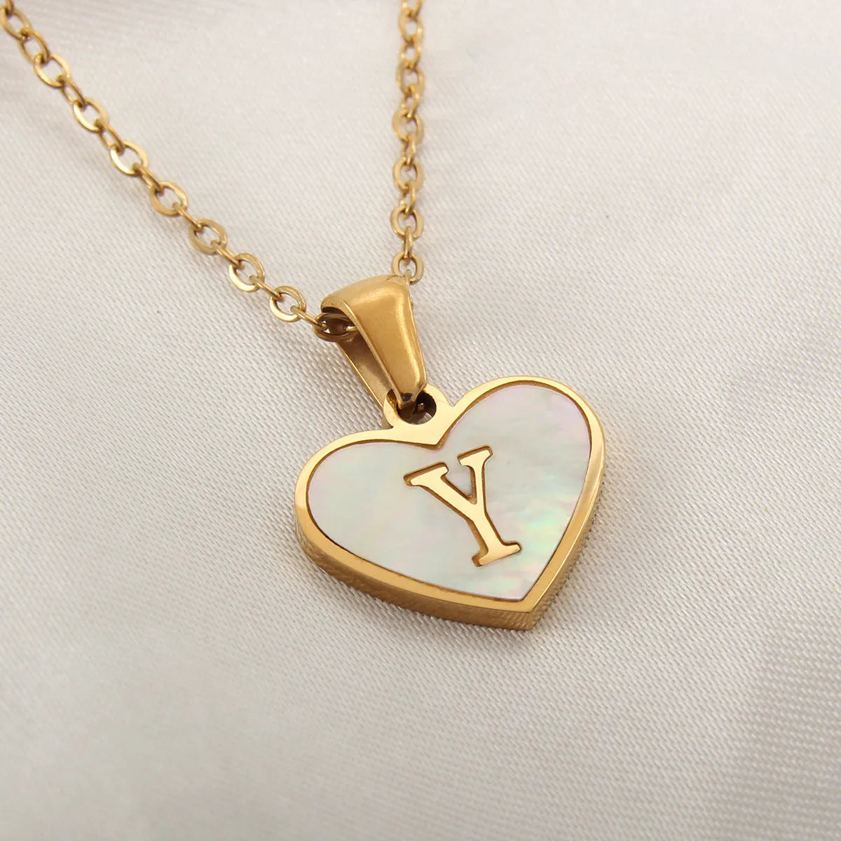 Gold plated chain necklace with a white shell heart-shaped pendant personalised with a single letter initial.