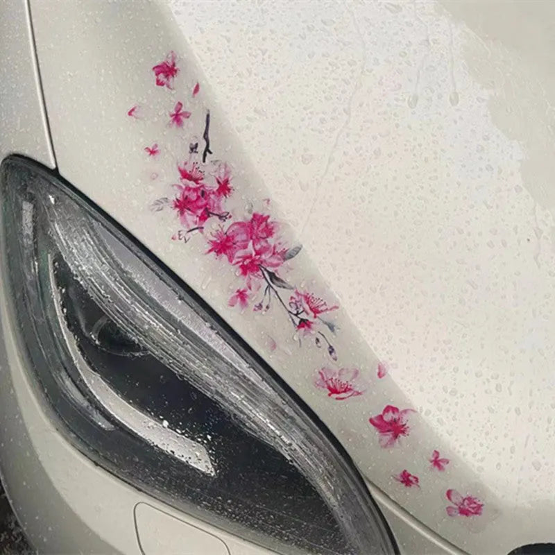 Close-up of a cherry blossom flower pattern on a PVC car sticker, shown with a peel-off backing.