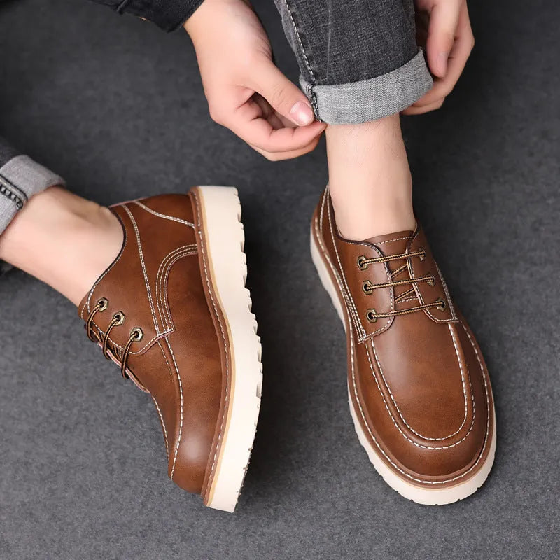 Men's black low-top Martin boots with round toe and rubber sole on a neutral background