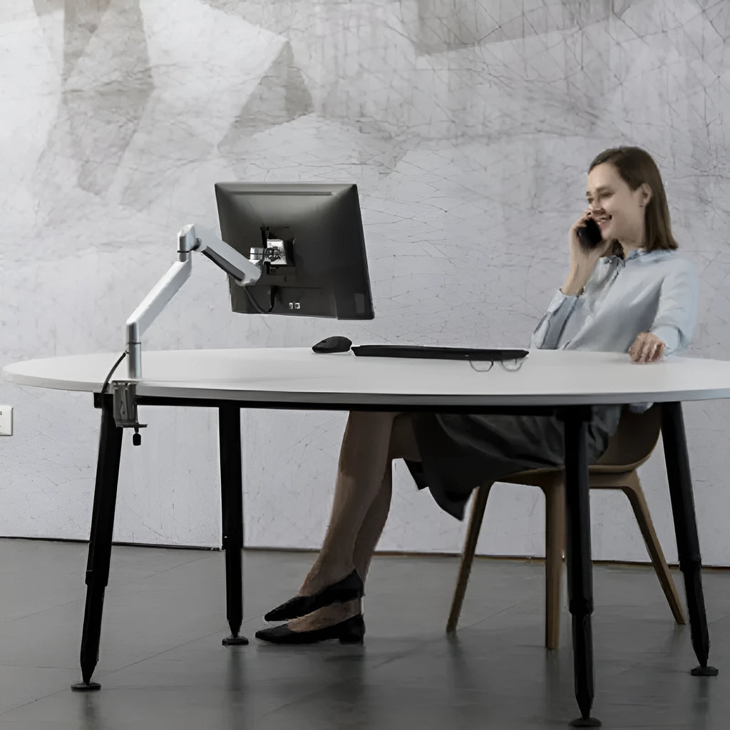 Black aluminium laptop stand with adjustable arm bracket raised above a desk.