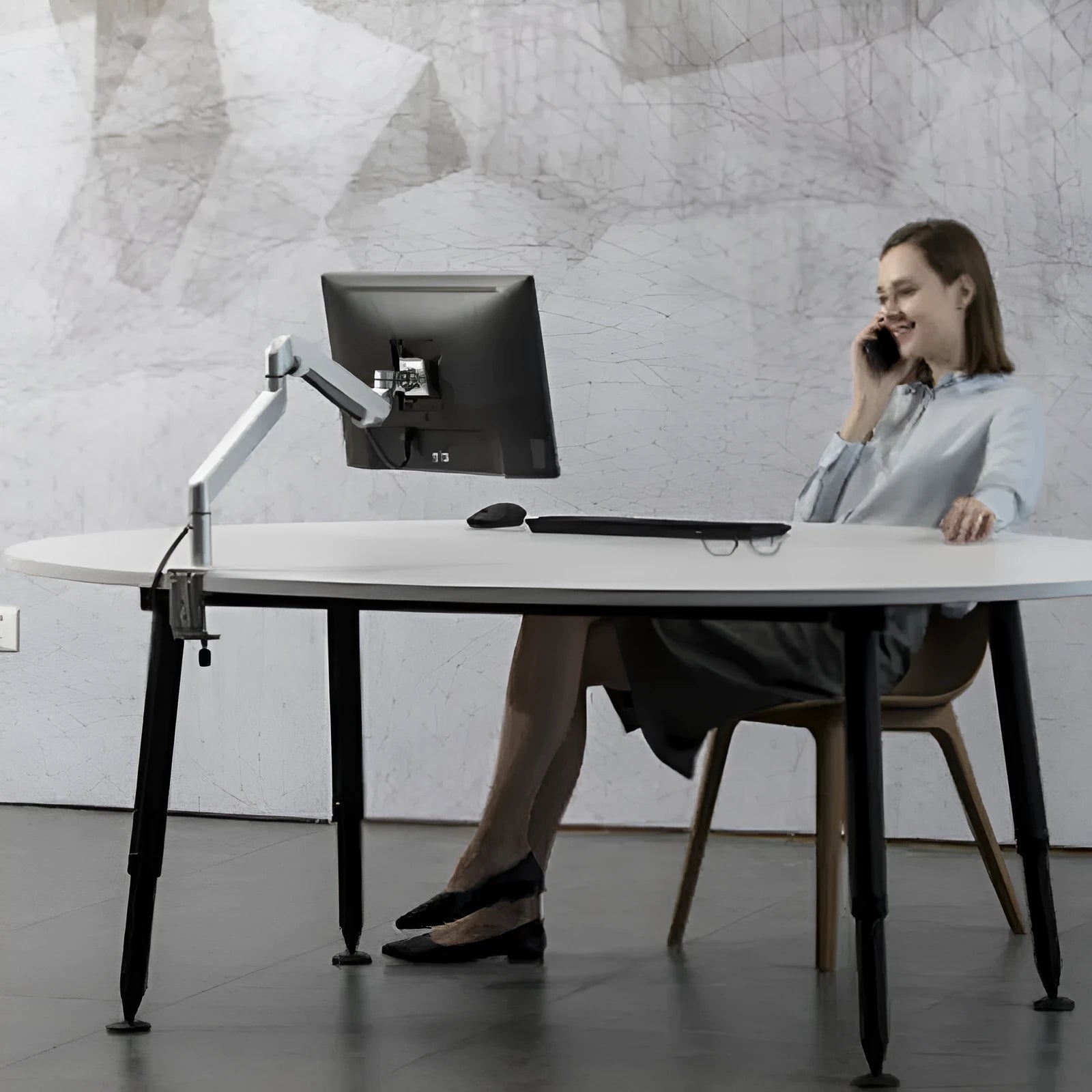 Black aluminium laptop stand with adjustable arm bracket raised above a desk.