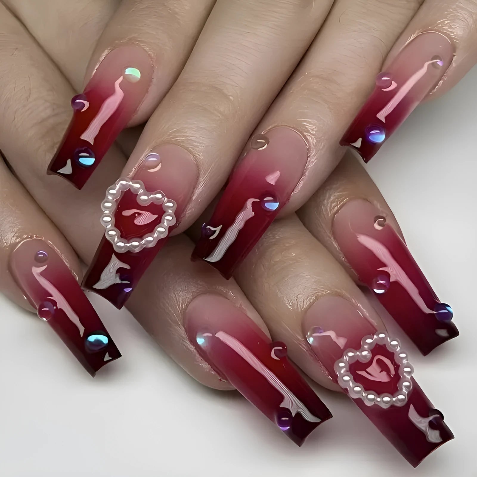 Wine red gradient fake nail tips with heart and plaid pattern, long ballet style, shown with jelly glue and rubbing cloth.
